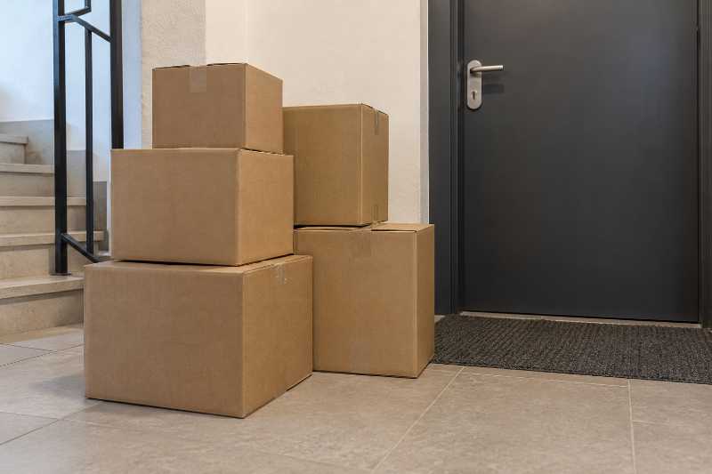 Cartons entreposés près d'une porte d'entrée fermée, en attente de la date d'installation
