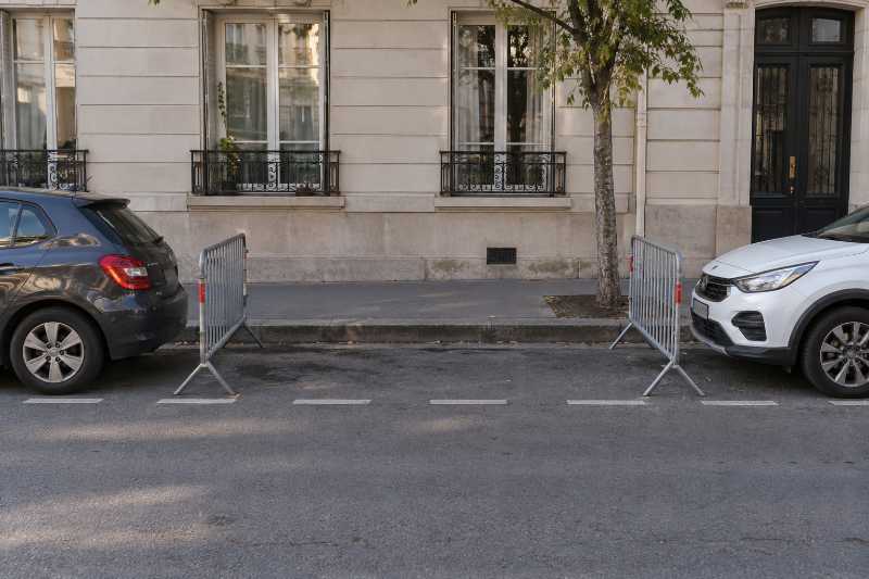 Barrières de réservation déjà installées la veille sur une place de stationnement libre