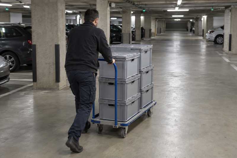Chariot chargé de caisses d'archives dans un parking souterrain de bureaux