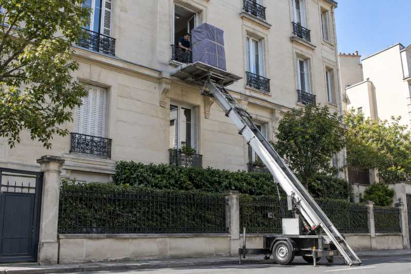 Sortie d'une armoire par une fenêtre d'étage à l'aide d'un monte-meuble